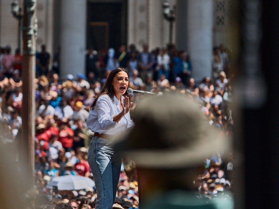 Alexandria Ocasio-Cortez speaks on stage in front of thousands of people