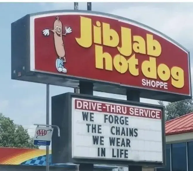 jib jab hot dog sign with a quote from A Christmas Carol from Scrooge's dead business partner Marley, "We forge the chains we wear in life." which implies some sort of cosmic justice which doesn't exist, the only justice we get we have to fight for imposed by humanity on itself but it's fun to think people who support and perpetrate crimes against humanity like billionaires get justice