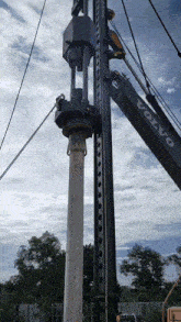 animated gif of a crane lifted like driver driving a heavy concrete prefab pile.
